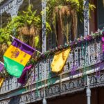 A building in the French Quarter of New Orleans decorated with colorful beads, flags, and banners to celebrate Mardi Gras.