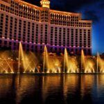 The Fountains of Bellagio in Las Vegas shoot out water at night, while the resort stands tall behind it.