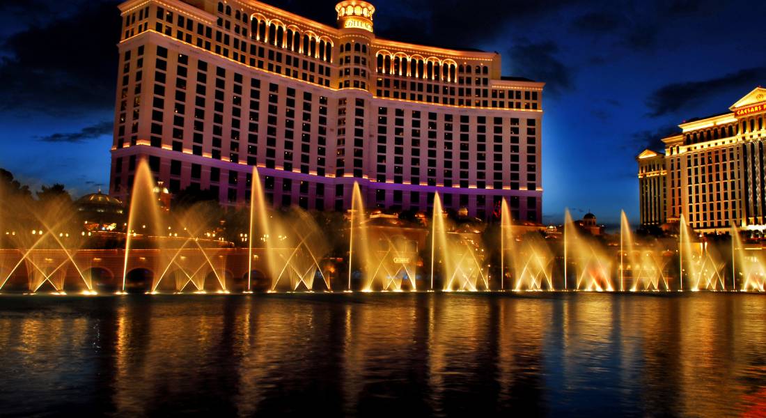 The Fountains of Bellagio in Las Vegas shoot out water at night, while the resort stands tall behind it.